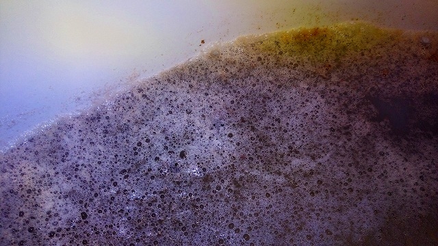 配管内からでた汚れによって茶色に染まった浴槽内のお湯